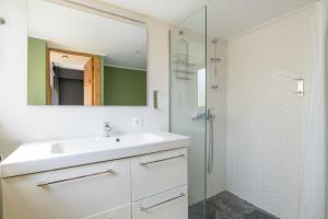 biała łazienka z umywalką i prysznicem w obiekcie Holodek Apartments : Parthenon w Atenach