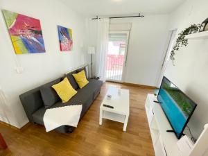 sala de estar con sofá y TV en Casa Pyrene - Acogedor apartamento familiar, en Sabiñánigo