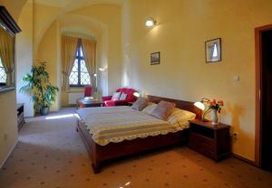 um quarto com uma cama e um sofá num quarto em Zamek Cerveny Hradek em Jirkov