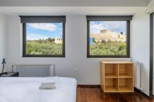 a white bedroom with two windows and a bed at Holodek Apartments : Parthenon in Athens