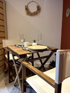 a wooden table with two wine glasses on top of it at La suite, avec jacuzzi & sauna in Muret
