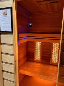 a small sauna with wooden walls and wooden floors at La suite, avec jacuzzi & sauna in Muret