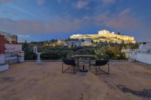 een tafel en twee stoelen op een dak met een kasteel bij Holodek Apartments : Parthenon in Athene