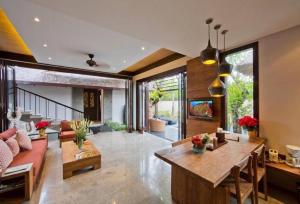 una sala de estar con un sofá y una mesa en Villa Canthy@Seminyak, en Seminyak