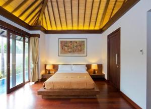a bedroom with a bed with a yellow ceiling at Villa Canthy@Seminyak in Seminyak