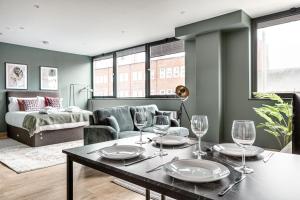 una sala de estar con una mesa con copas de vino. en Modern Apt, town centre, 4 guests, pkg, wifi by Tent serviced apartments en Farnborough