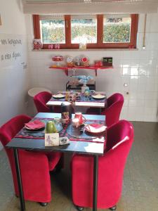 a room with a table with red chairs and a table with food at Bed & Breakfast Agli Aceri in Verona