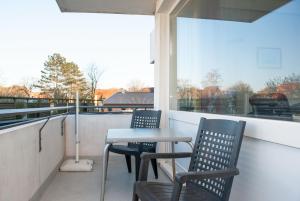un balcone con 2 sedie, un tavolo e una finestra di Haus Hanseatic, Wohnung 107 a Duhnen