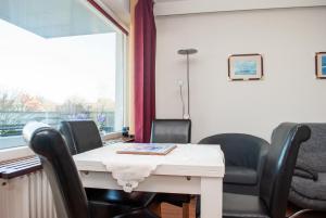 una sala conferenze con sedie, tavolo e finestra di Haus Hanseatic, Wohnung 107 a Duhnen