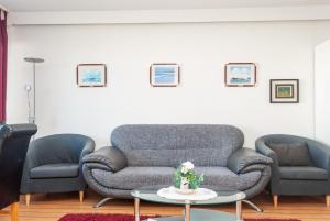 un soggiorno con 2 divani e un tavolo di Haus Hanseatic, Wohnung 107 a Duhnen