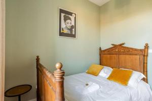 a bedroom with a bed with white sheets and yellow pillows at luxury Villa Marie Emeraude Paris Orly Jacuzzi in Draveil +32 photos