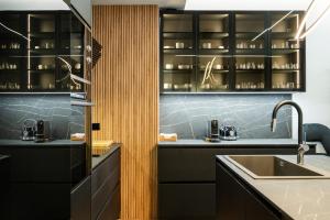 a kitchen with black cabinets and a sink at #Dahlia by halu! Apartments in Thessaloniki