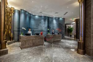 a lobby with two people sitting at desks in a building at Gao Shi Di Hot Spring Hotel Yangzhou in Yangzhou