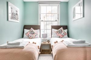 チャーツィーにあるHomely 2 beds apt up to 5 Guests-Wifi by Tent Serviced Apartmentsの青い壁と窓のある部屋にベッドが2つある