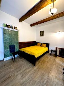 um quarto com uma cama amarela e uma lareira em MATOGÓWKA em Krzeszowice