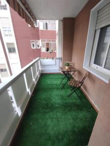 a balcony with two chairs and a green yard at Apartamento Ceuta in Murcia