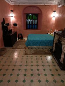 - une chambre avec un lit et une cheminée dans l'établissement Tiworgua, à Marrakech