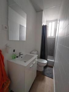 a bathroom with a sink and a toilet and a mirror at Apartamento Ceuta in Murcia
