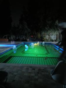 - une piscine avec des lumières vertes la nuit dans l'établissement Tiworgua, à Marrakech