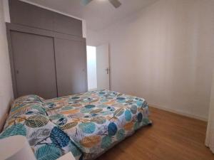 a bedroom with a bed with a colorful comforter at Apartamento Ceuta in Murcia