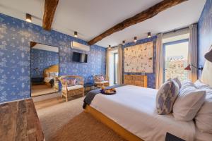 a bedroom with a large bed in a room with blue walls at THE PINTA Boutique in Armamar