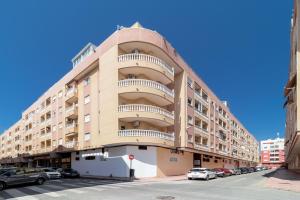 un gran edificio de apartamentos con coches aparcados en un aparcamiento en Espanatour SAN JULIAN 41, en Torrevieja