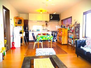 a living room with a table and a kitchen at シーカレント　ゆな　CHIKURA in Chikura