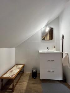 ein weißes Badezimmer mit einem Waschbecken und einer Bank in der Unterkunft MATOGÓWKA in Krzeszowice
