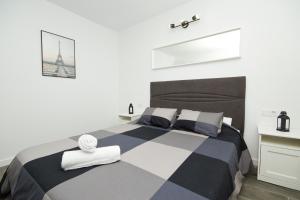 a bedroom with a black and white bed with a cross on the wall at Los Alonsos - Open Mall in Arrecife