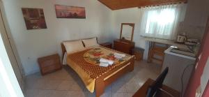 a small bedroom with a bed and a mirror at Apartments Elena in Kavos