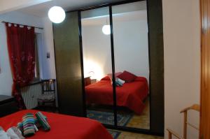 1 dormitorio con cama roja y espejo en Ca’ Ruset, en Roccaforte Mondovì