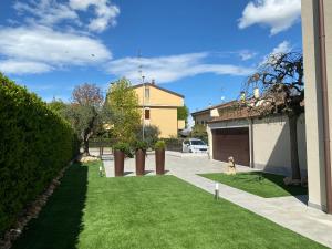 een groene tuin met een huis en een oprit bij Montevecchi13 in Imola