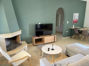 a living room with a couch and a tv at Amalfi Complex in Kato Almiri