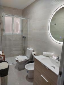 a bathroom with a toilet and a sink and a shower at Apartamento 1º linea playa Torrenueva, Motril, Granda in Torrenueva +15 photos