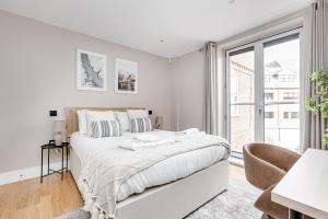 Habitación blanca con cama y ventana en Charming 1 BR apt , town centre, wifi, free parking by Tent Serviced Apartments en Staines