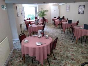 a dining room with tables and chairs with pink tablecloths at Southview Hotel in Blackpool +22 photos