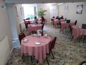 a dining room with tables and chairs with pink tablecloths at Southview Hotel in Blackpool