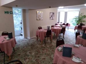 a room with tables and chairs with pink tablecloths at Southview Hotel in Blackpool