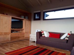 a living room with a couch and a large window at Arelauquen , Terrazas del Polo in San Carlos de Bariloche