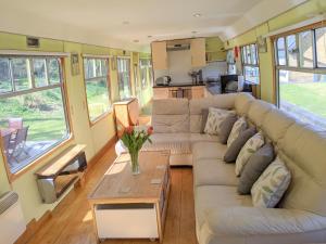 a living room with a couch and a table at Carriage 1 - Coalport Station Holidays in Telford