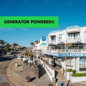 a building with a sign that reads generator powered at Bayview Hotel in Plettenberg Bay