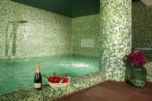 a bath tub with a bottle of wine and a bowl of fruit in at Ona Marinas de Nerja Spa Resort in Nerja