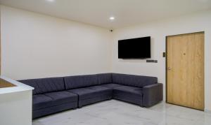 a living room with a couch and a flat screen tv at Treebo Trend Grand Lotus in Surat