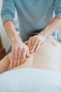 une femme reçoit un massage sur son estomac dans l'établissement AR Boutique Apartments, à Bergame