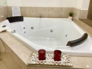 a white bath tub with rocks in a bathroom at Linger a While Chalet on Gallery Walk with Spa, Fireplace, WiFi & Netflix in Mount Tamborine