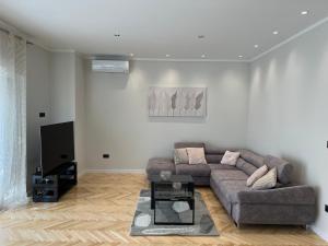 a living room with a couch and a tv at Two Palms in Duće