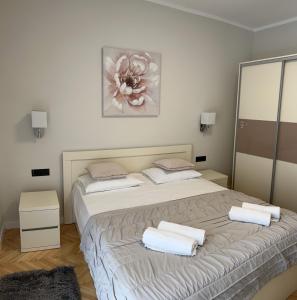 a bedroom with a bed with towels on it at Two Palms in Duće