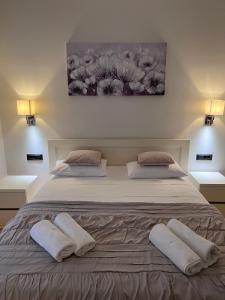 a bedroom with a large bed with two white pillows at Two Palms in Duće