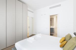 um quarto branco com uma cama e um sofá em Easylife - Lussuosa dimora con rooftop vista Duomo em Milão