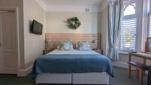 a bedroom with a large bed with a blue blanket at Beach Lodge in Bournemouth